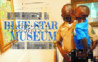 "Experience a Blue Star Museum this summer!" Father and son enjoy art in a museum.